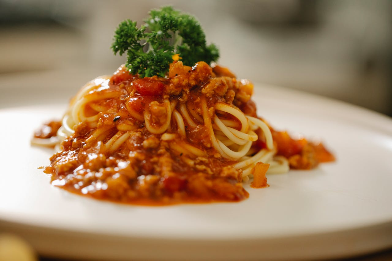 The Art of Drawing Readers In: Your attractive post title goes here Close-up of a tempting spaghetti Bolognese dish topped with fresh parsley, perfect for Italian cuisine lovers.